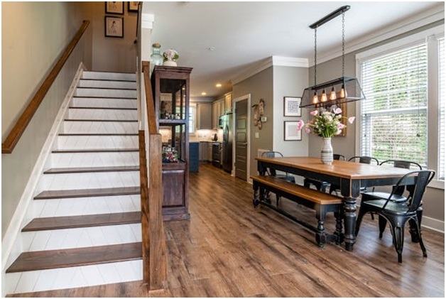 a kitchen and dining areas with dark wood flooring and staircase to the second floor